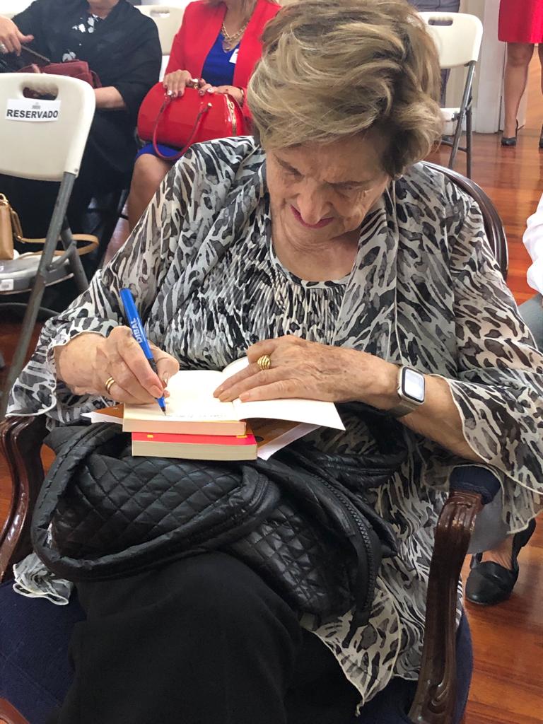 La Sra. Lara Ríos firmando libros para la biblioteca de escuela la Trinidad.